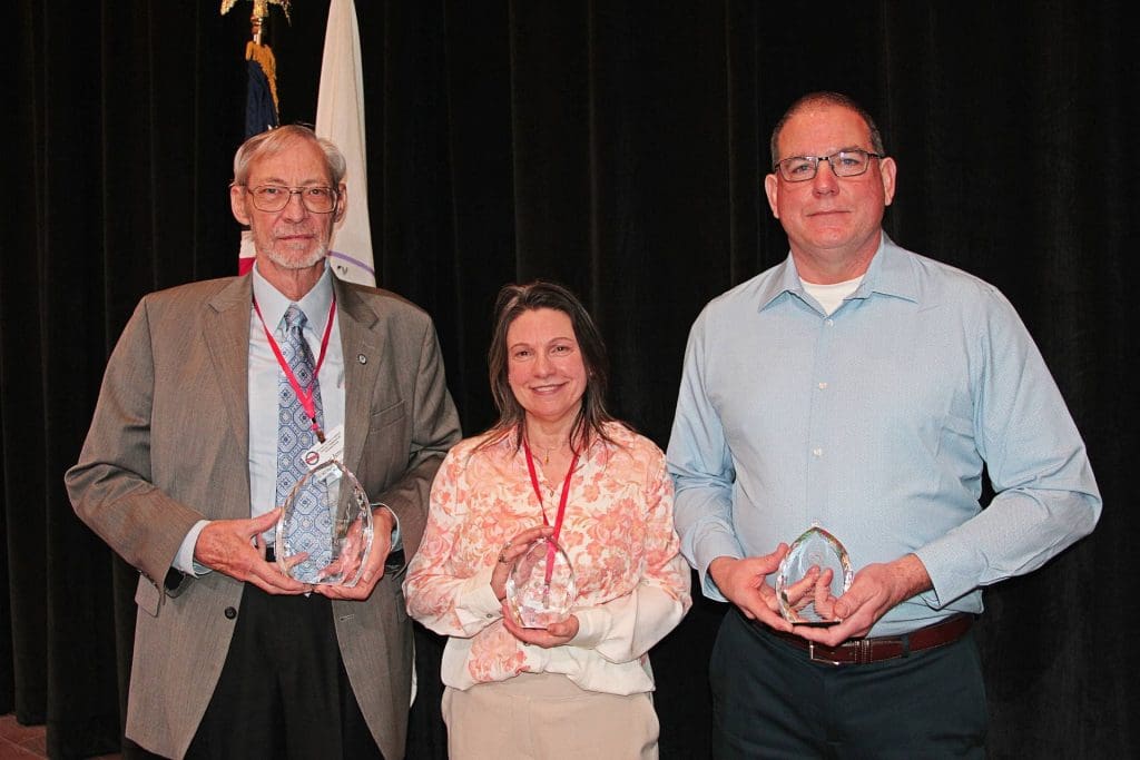 Peter Jensen, Dawn Robinson, and Ben Warrington show off their 2025 Governor’s Conference Awards.