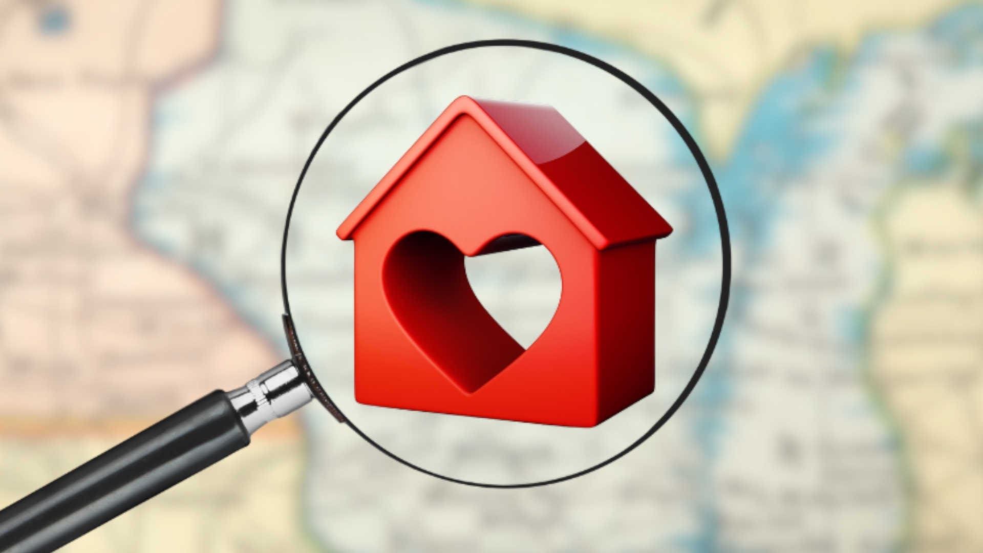 A magnifying glass over a house with a heart in the center of it.