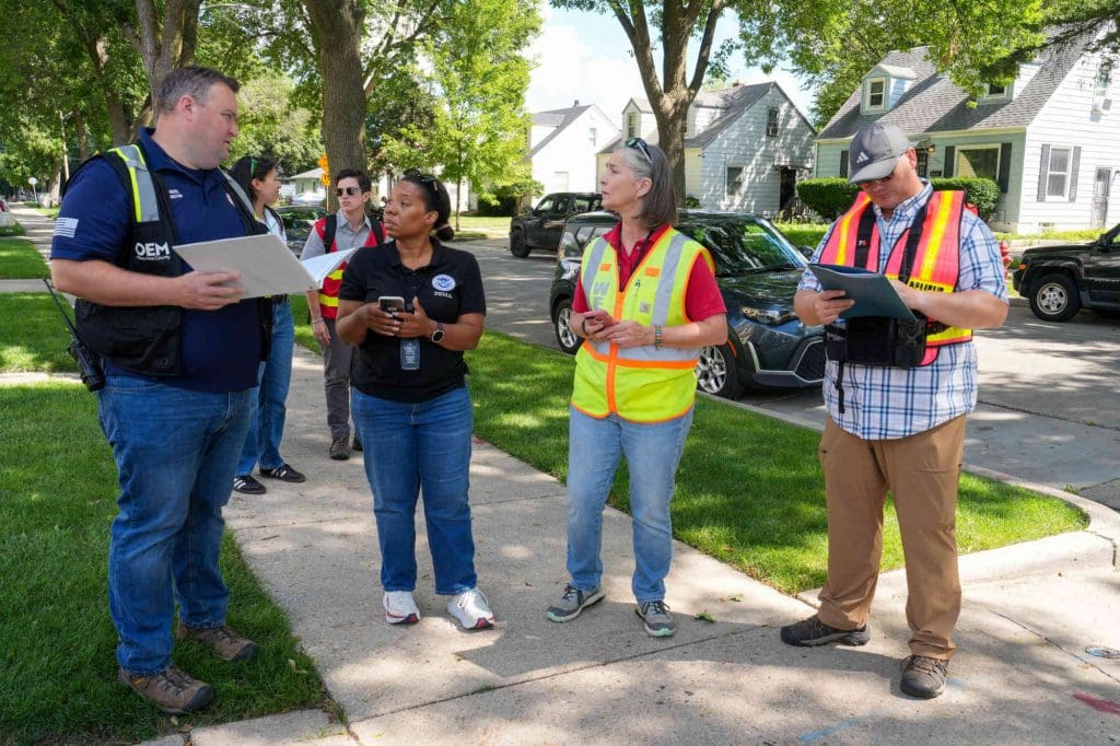 People with safety gear doing a preliminary damage assessment.
