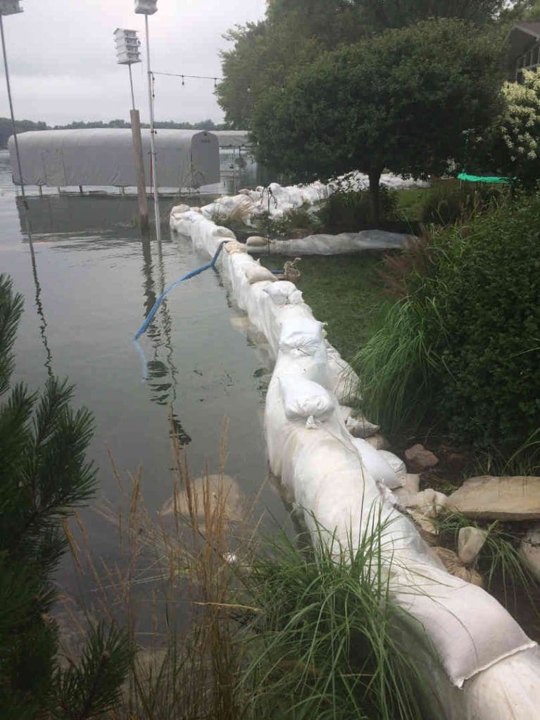 a line of sandbags holding back a lake from a property