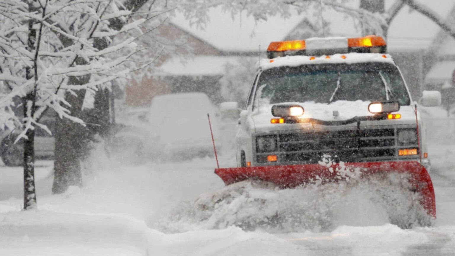 A plow truck pushing snow off the road