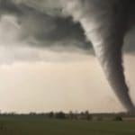 A tornado at a distance in a farm field