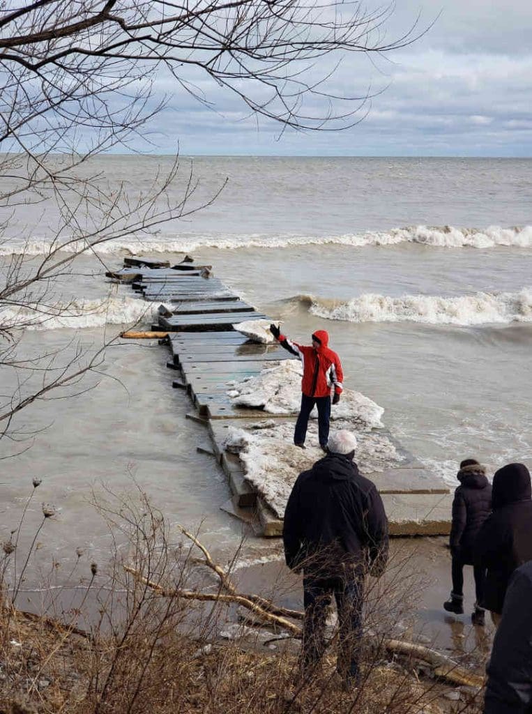 A dock covered in ice with cleanup crews on site