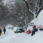 a street full of snow covered cars