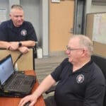 People working on laptops in the SEOC during the flooding of April 2026.