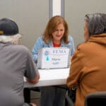 A FEMA employee helping folks with paperwork