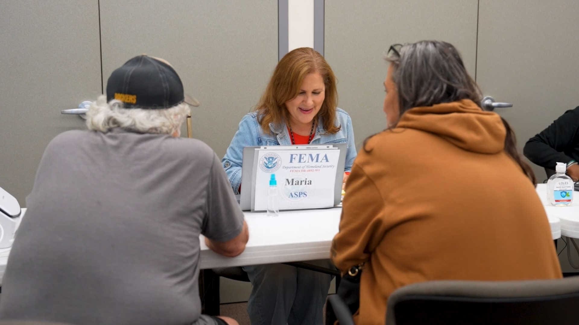 A FEMA employee helping folks with paperwork