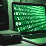 Laptop with a generic 1 and 0 wallpaper with a green tone