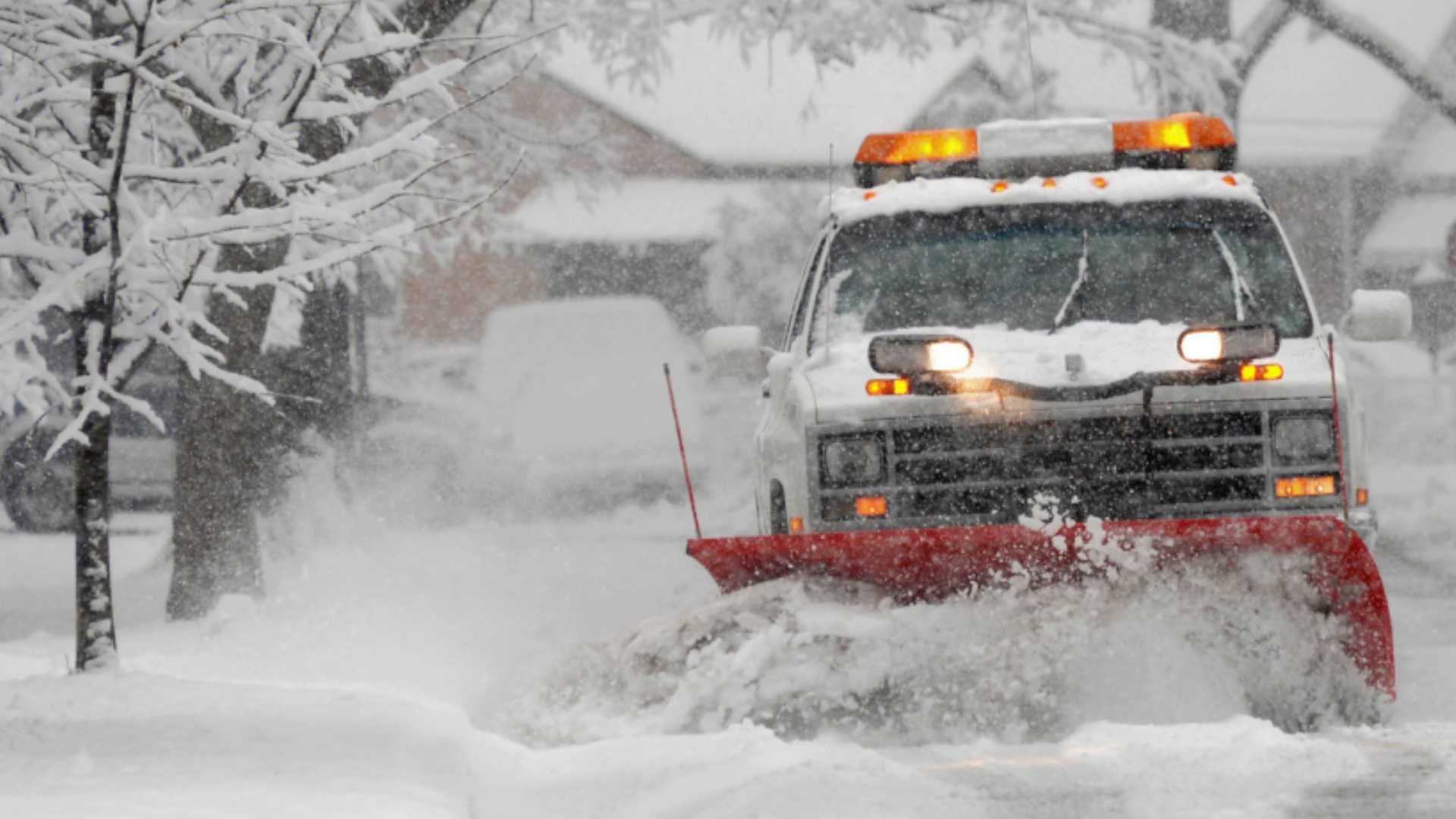 A plow truck pushing snow off the road